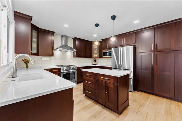 a kitchen with kitchen island stainless steel appliances a sink stove and refrigerator