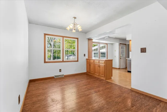 an empty room with chandelier and windows