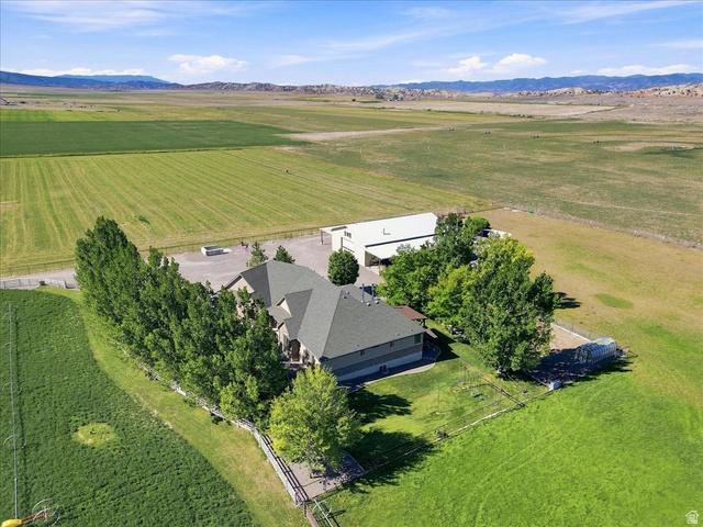 11290 South Southfield Road Mayfield, UT 84643 - Photo 10 of 103 Countryside estate nestled on expansive grounds featuring a two-story residence with a charcoal-toned roof, mature landscaping with established trees providing natural screening, a large agricultural outbuilding, and manicured lawn acreage with distant mo