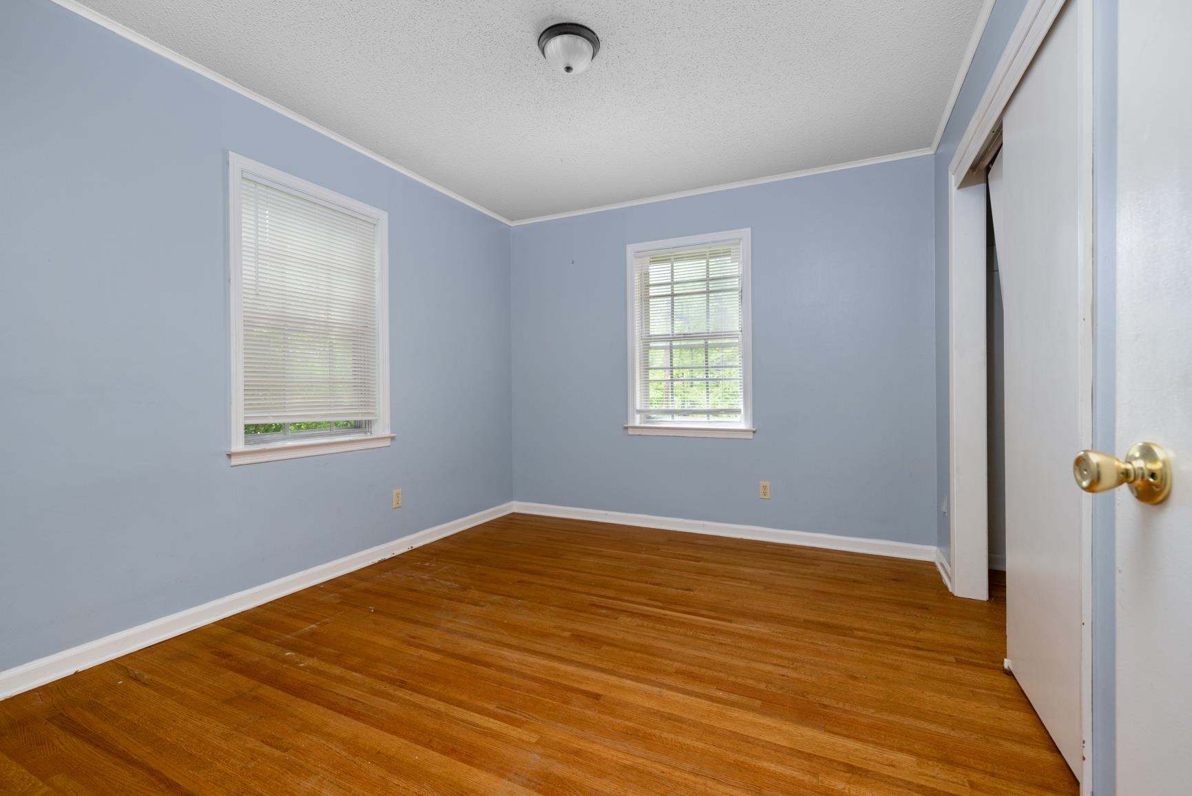 3853 Range Line Road Memphis, TN 38127 - Photo 13 of 18 Unfurnished bedroom featuring wood finished floors, a textured ceiling, a closet, and ornamental molding