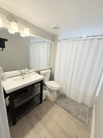 a bathroom with a sink toilet a mirror and a shower