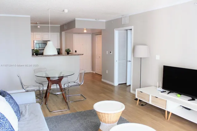 a living room with furniture a flat screen tv and a toilet