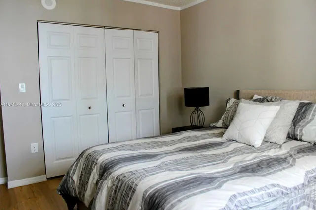 a bedroom with a bed and wooden floor