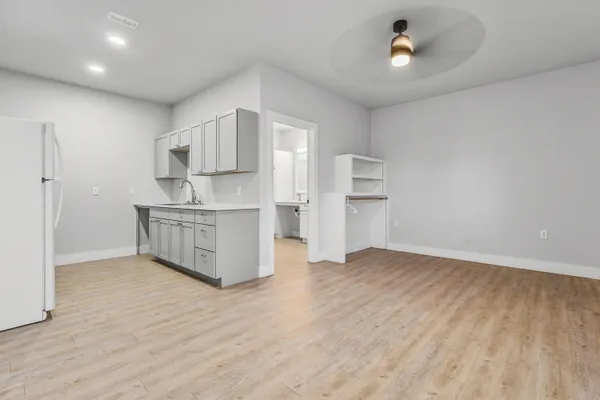 a view of kitchen with a sink wooden cabinet and windows