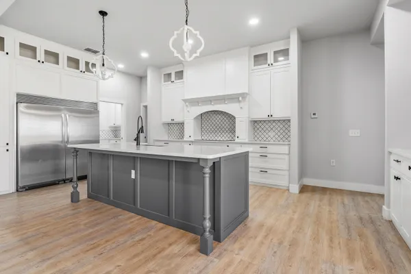a kitchen with kitchen island granite countertop a sink cabinets and stainless steel appliances