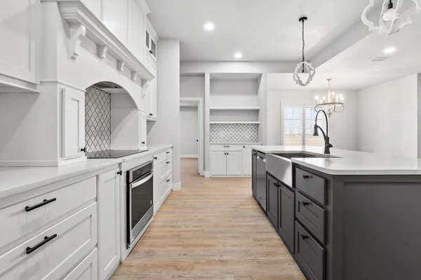 a large kitchen with a sink and dishwasher stove a refrigerator with wooden floor