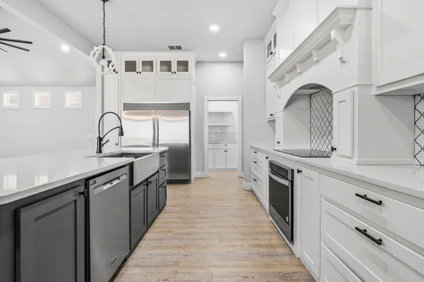 a large kitchen with granite countertop a sink and cabinets