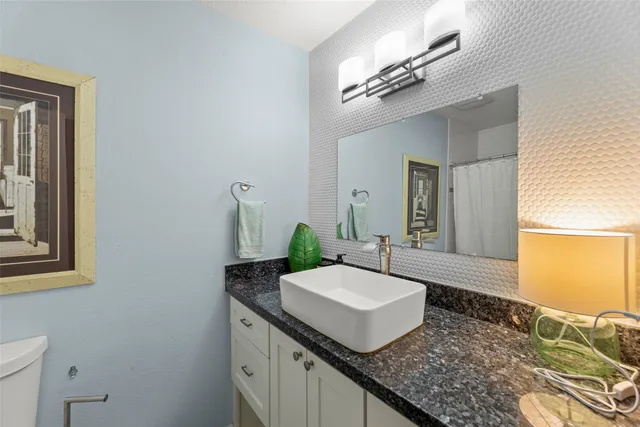 a bathroom with a granite countertop sink and a mirror