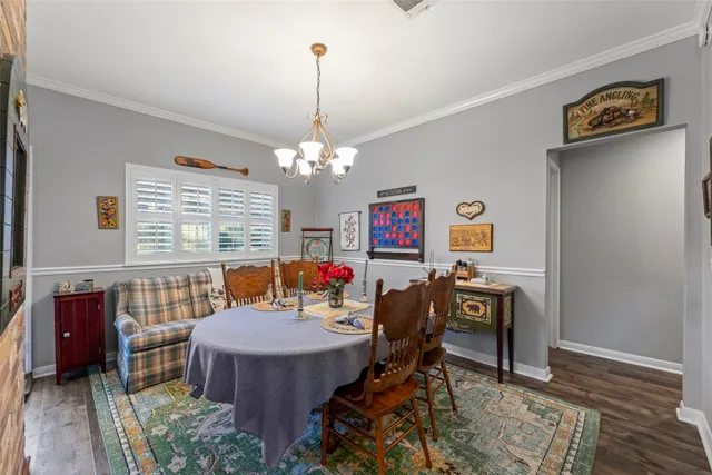 a view of a dining room with furniture a chandelier and wooden floor