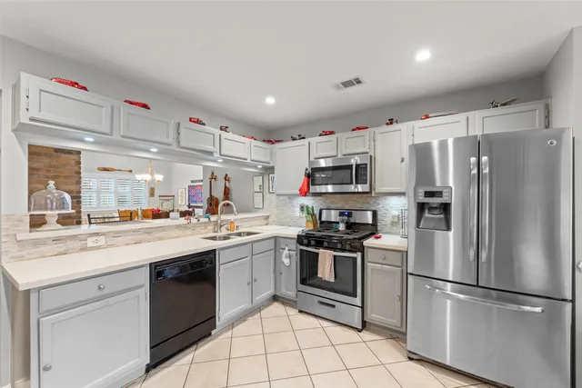 a kitchen with stainless steel appliances a sink cabinets and a refrigerator