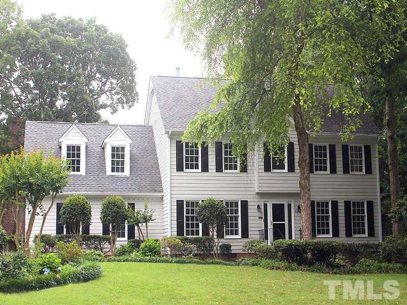 8333 Apple Orchard Way Raleigh, NC 27615 - Photo 1 of 25 a view of a white house with large windows and a yard with plants and large trees