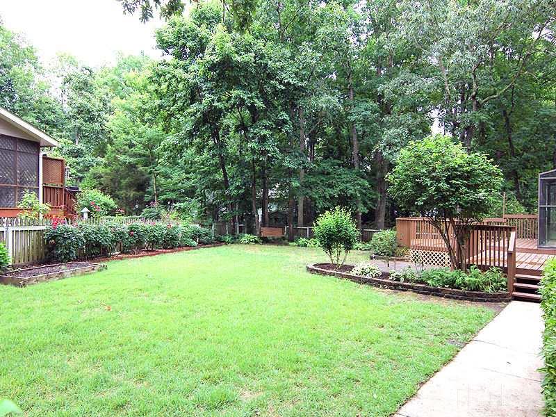 8333 Apple Orchard Way Raleigh, NC 27615 - Photo 2 of 25 a view of a backyard with plants and a garden
