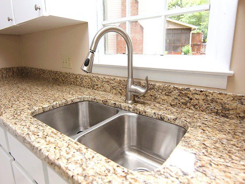 8333 Apple Orchard Way Raleigh, NC 27615 - Photo 11 of 25 a kitchen with a sink and a stove