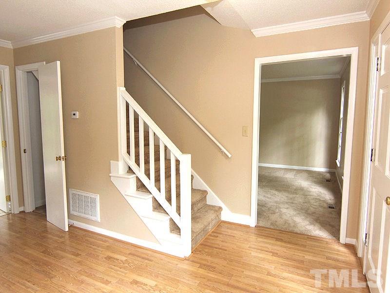 8333 Apple Orchard Way Raleigh, NC 27615 - Photo 5 of 25 a view of a hallway with wooden floor and staircase