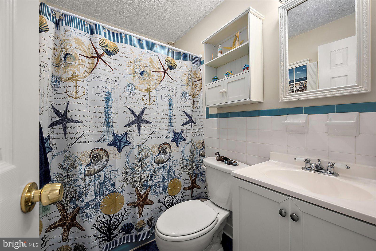 11603 Seaward Road, Unit 6 Ocean City, MD 21842 - Photo 25 of 43 a bathroom with a toilet sink and mirror