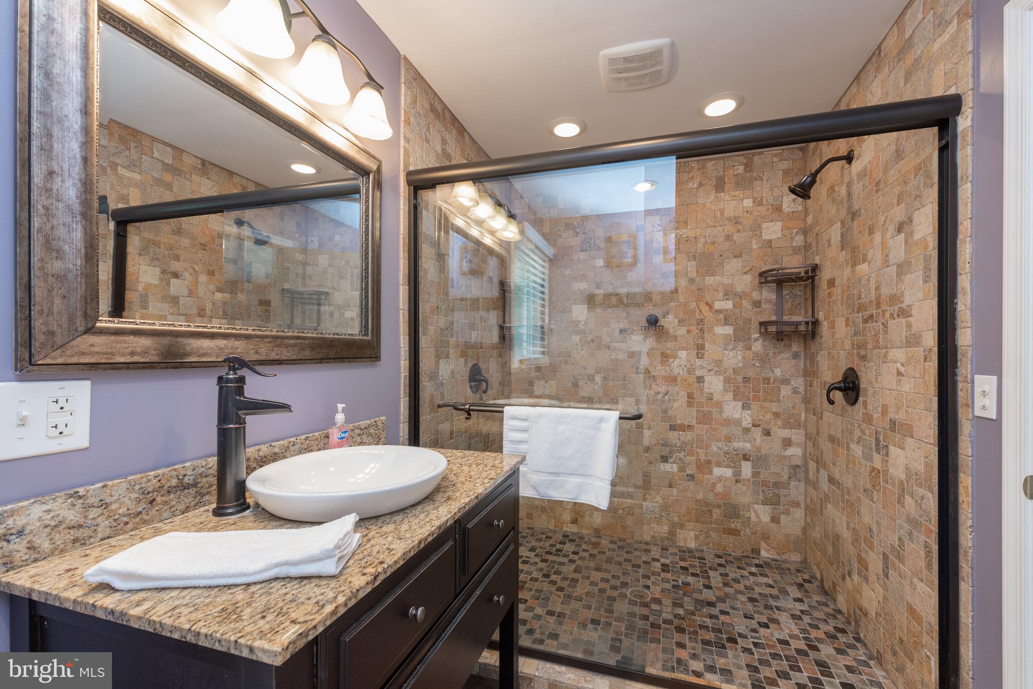 926 Marsh Hill Road McHenry, MD 21541 - Photo 26 of 70 a bathroom with a granite countertop sink a mirror a vanity and a shower