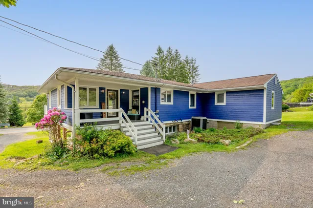 a living room with furniture a flat screen tv and a window