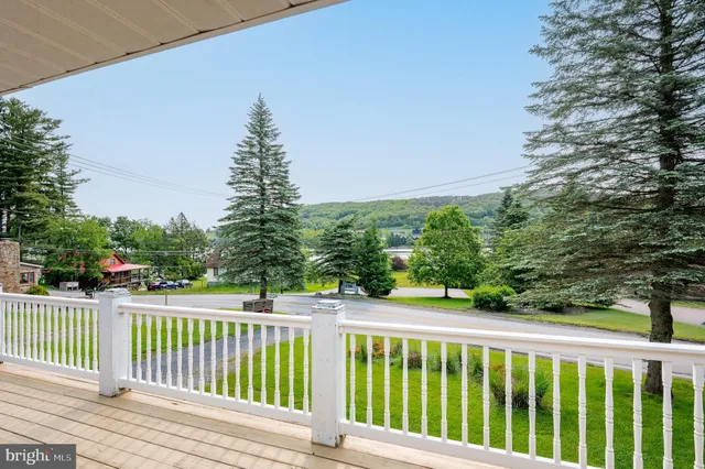 a kitchen with stainless steel appliances granite countertop a stove top oven a sink dishwasher a dining table and chairs with wooden floor