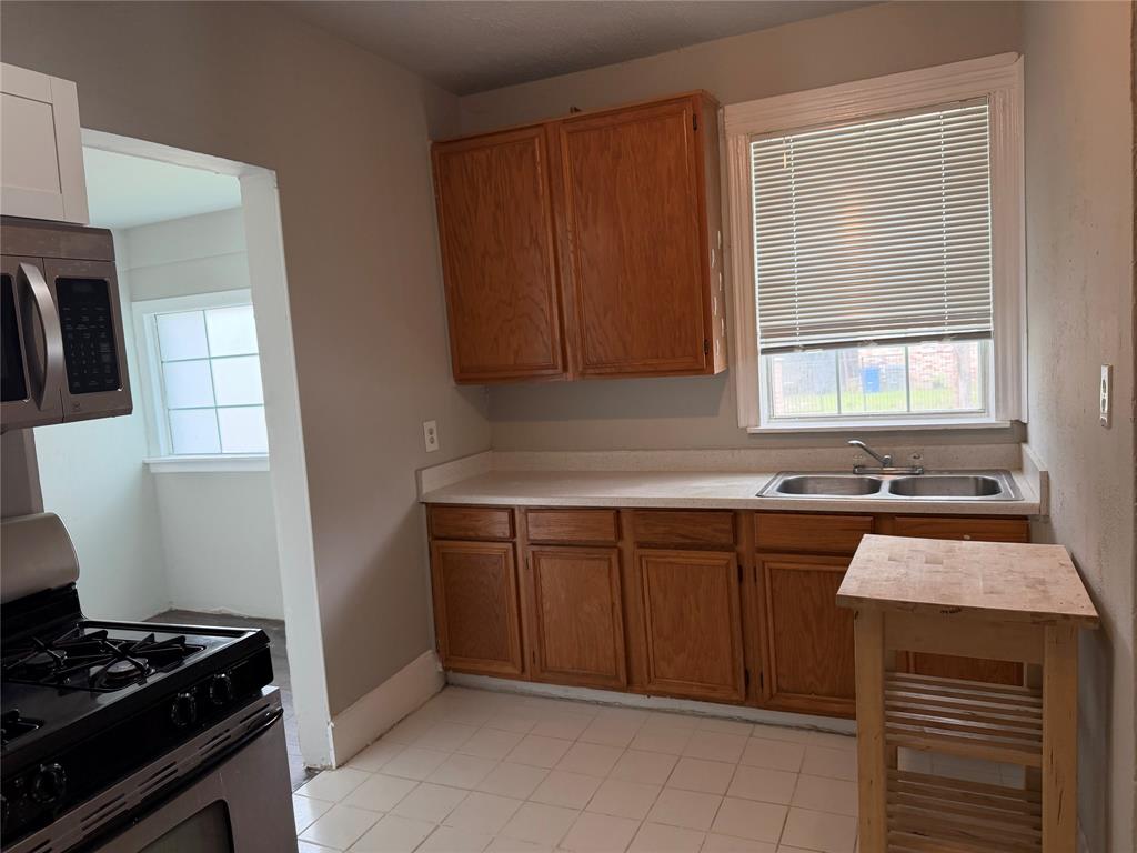 801 Wayne Street Dallas, TX 75223 - Photo 9 of 15 a kitchen with a sink a stove cabinets and a window