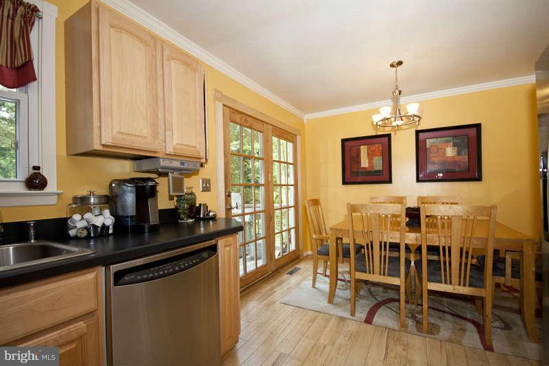 7758 Telegraph Road Severn, MD 21144 - Photo 7 of 29 a kitchen with stainless steel appliances a stove a sink a microwave and dining table with wooden floor