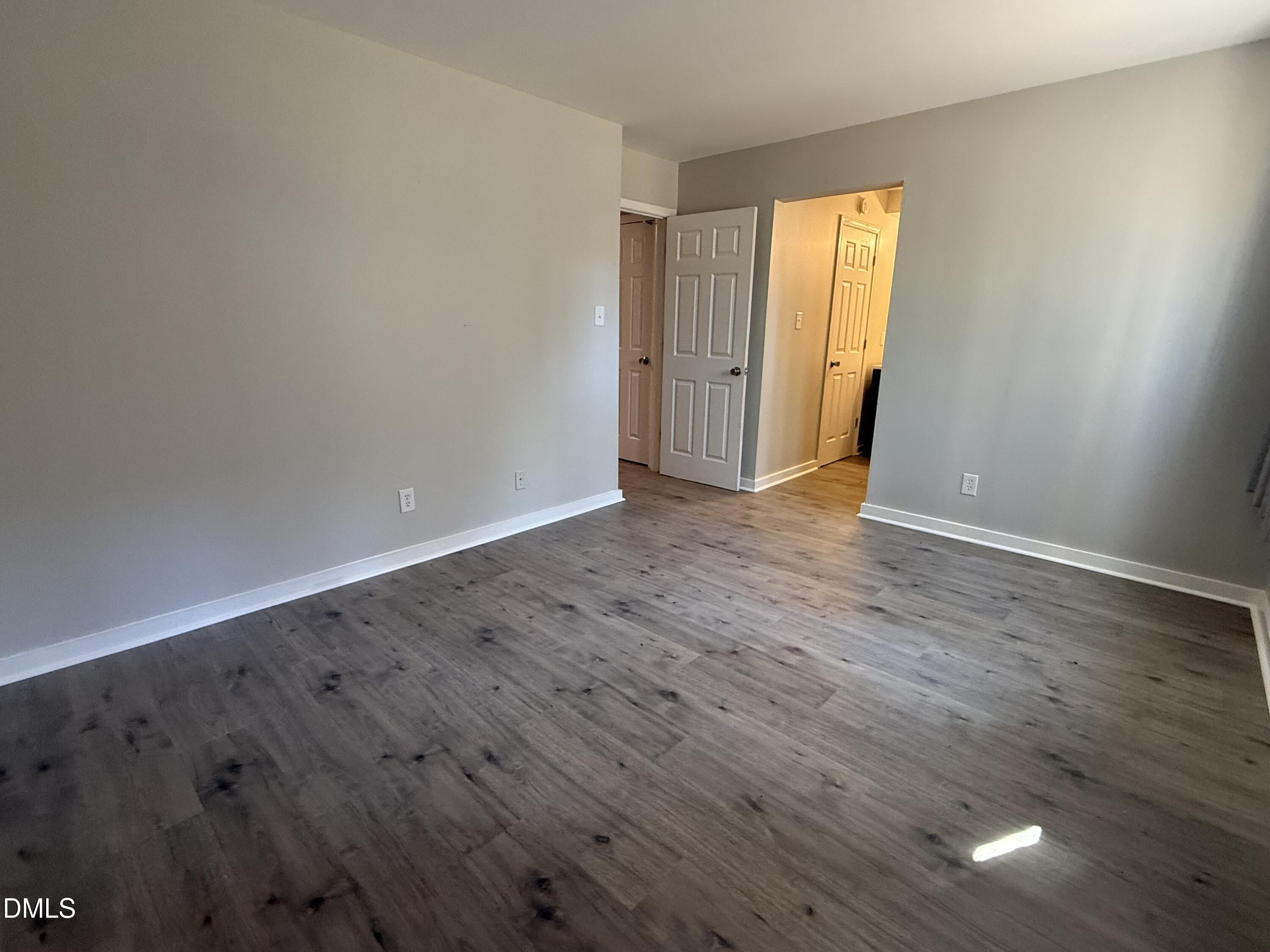 1295 Schaub Drive, Unit C Raleigh, NC 27606 - Photo 12 of 15 a view of an empty room with wooden floor and a window