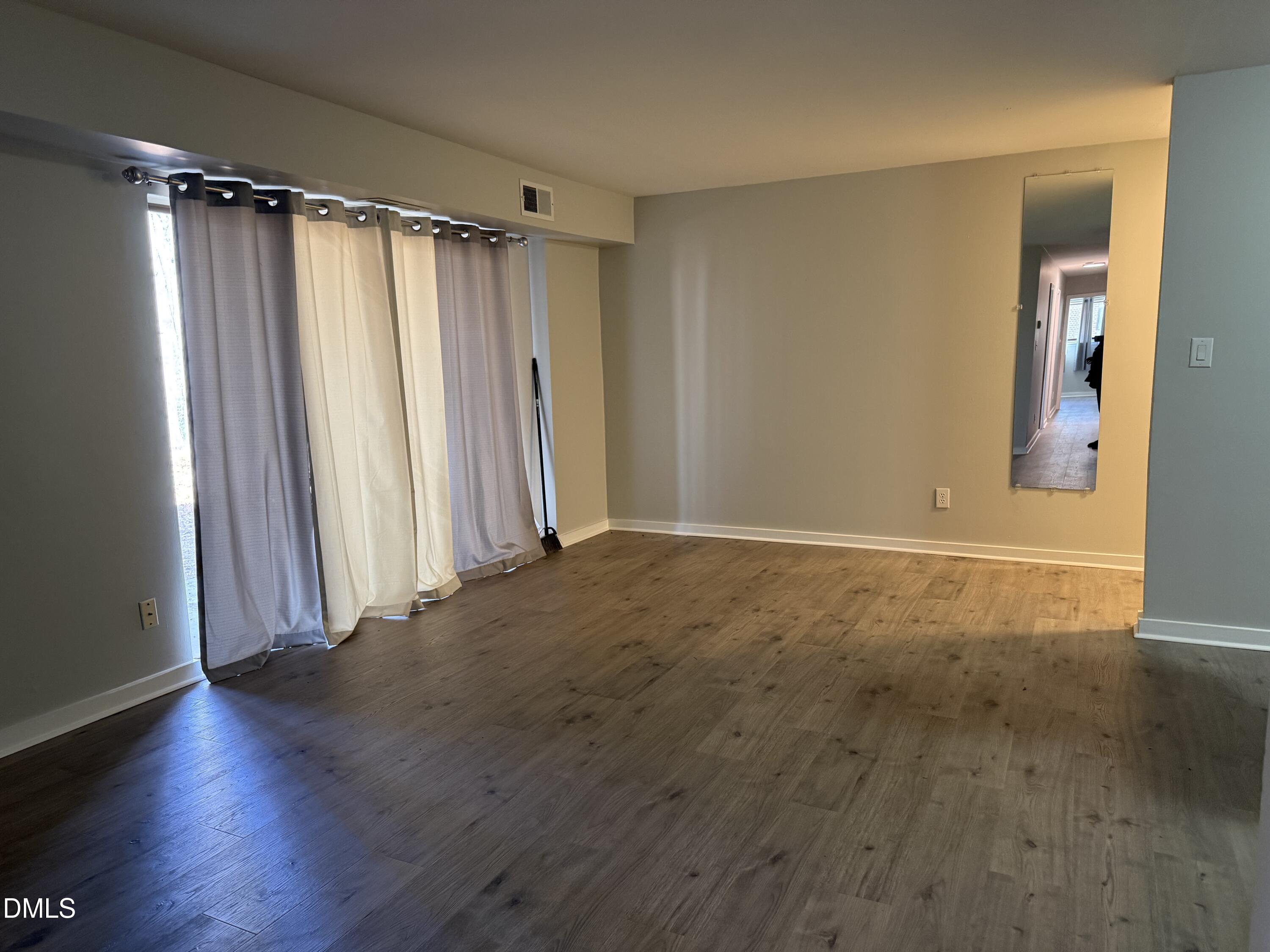 1295 Schaub Drive, Unit C Raleigh, NC 27606 - Photo 13 of 15 an empty room with wooden floor and a window