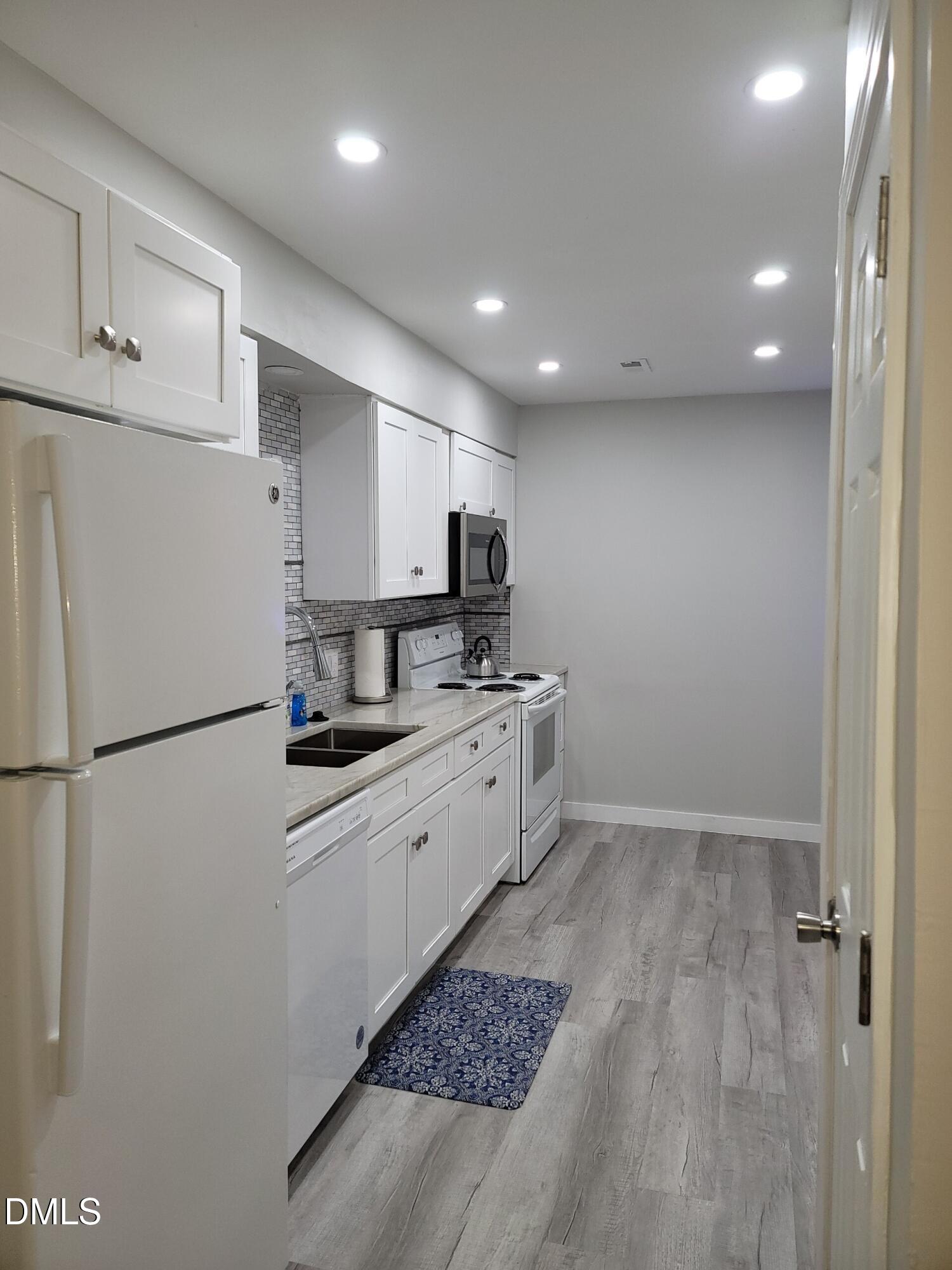 1295 Schaub Drive, Unit C Raleigh, NC 27606 - Photo 6 of 15 a kitchen with a refrigerator a stove top oven and a sink