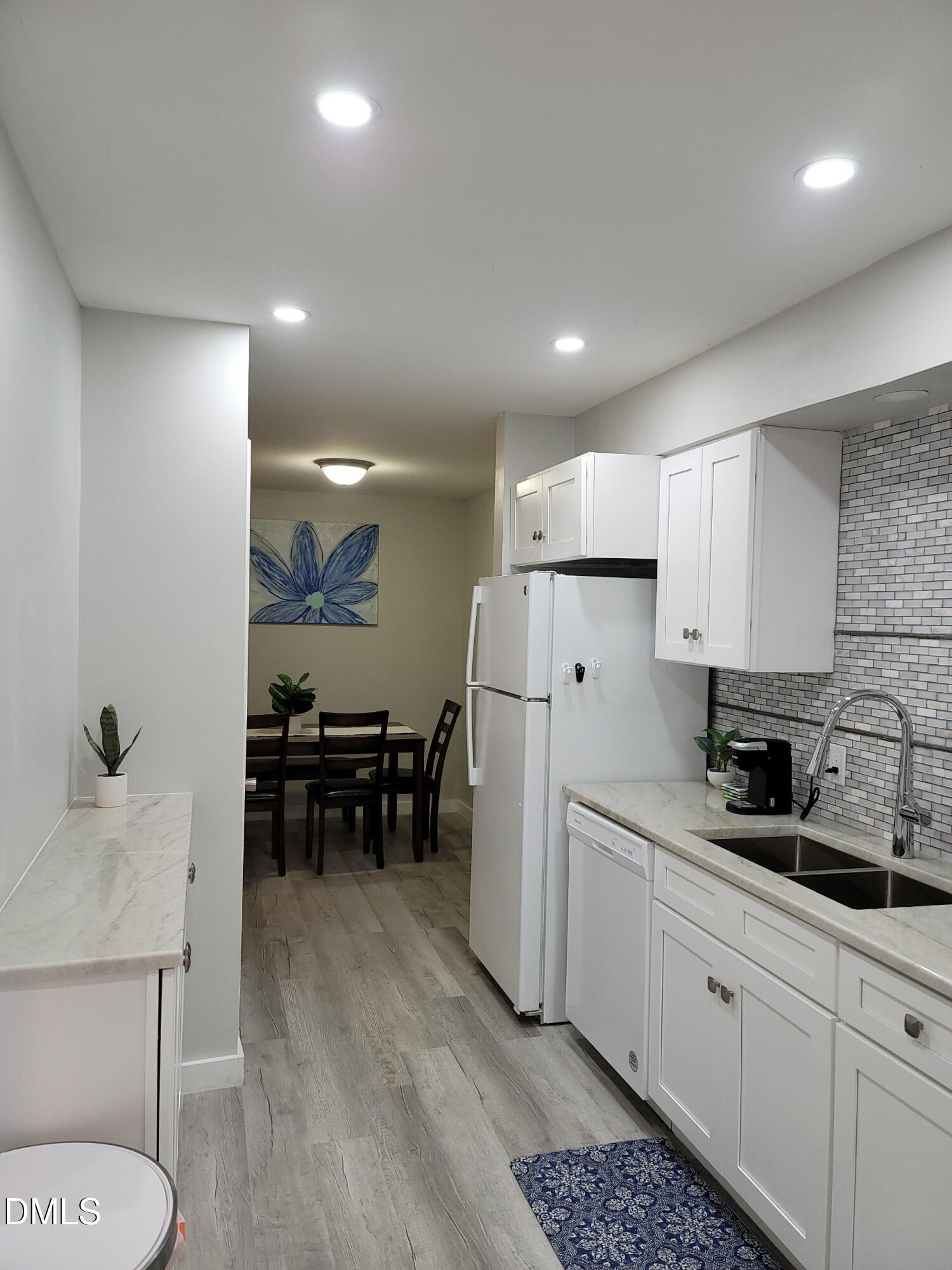 1295 Schaub Drive, Unit C Raleigh, NC 27606 - Photo 7 of 15 a kitchen with refrigerator and chairs