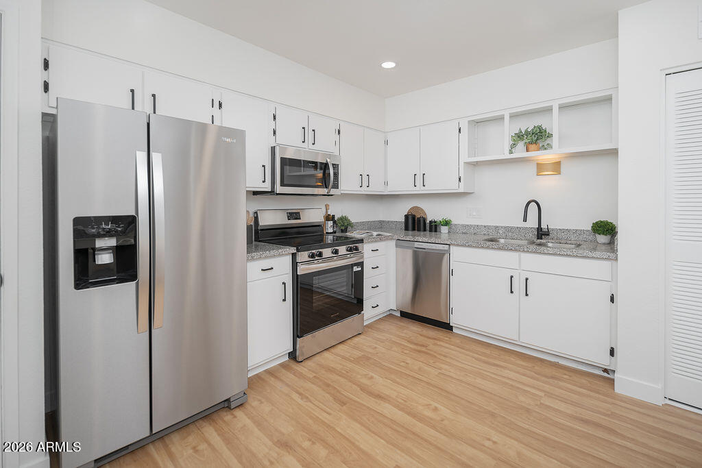 720 South Dobson Road, Unit 85 Mesa, AZ 85202 - Photo 9 of 25 a kitchen with white cabinets white stainless steel appliances and sink