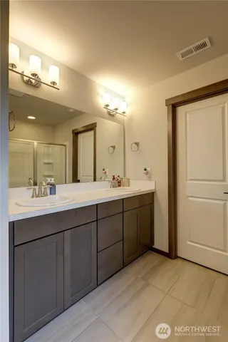a bathroom with a double vanity sink and a mirror