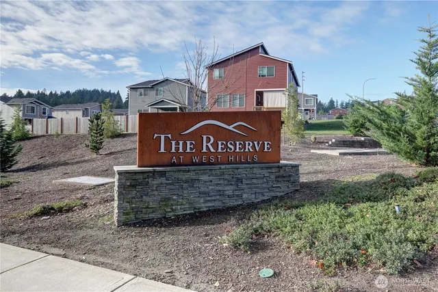 a view of sign board with buildings in the background