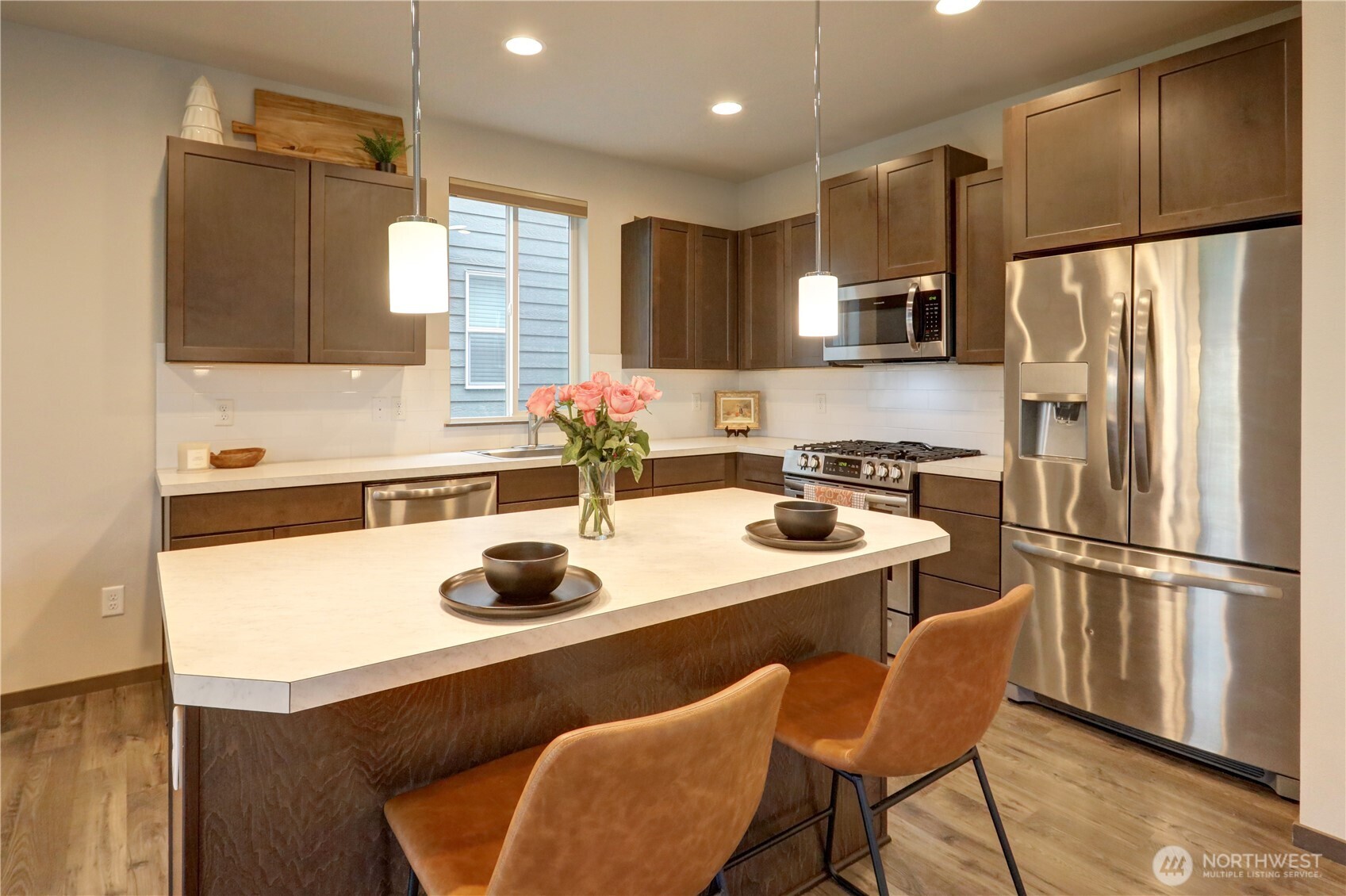 5154 Granger Street Bremerton, WA 98312 - Photo 10 of 26 a kitchen with a refrigerator a stove a sink and white cabinets with wooden floor