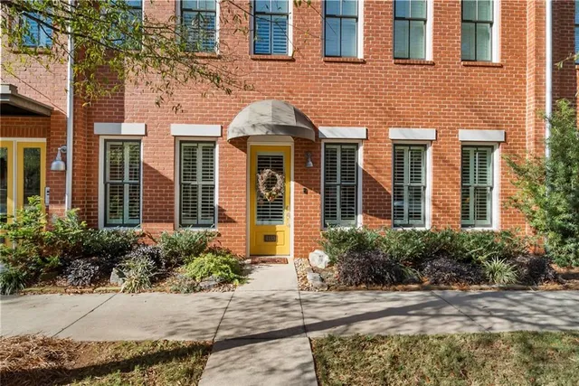 front view of a brick house with a small yard plants