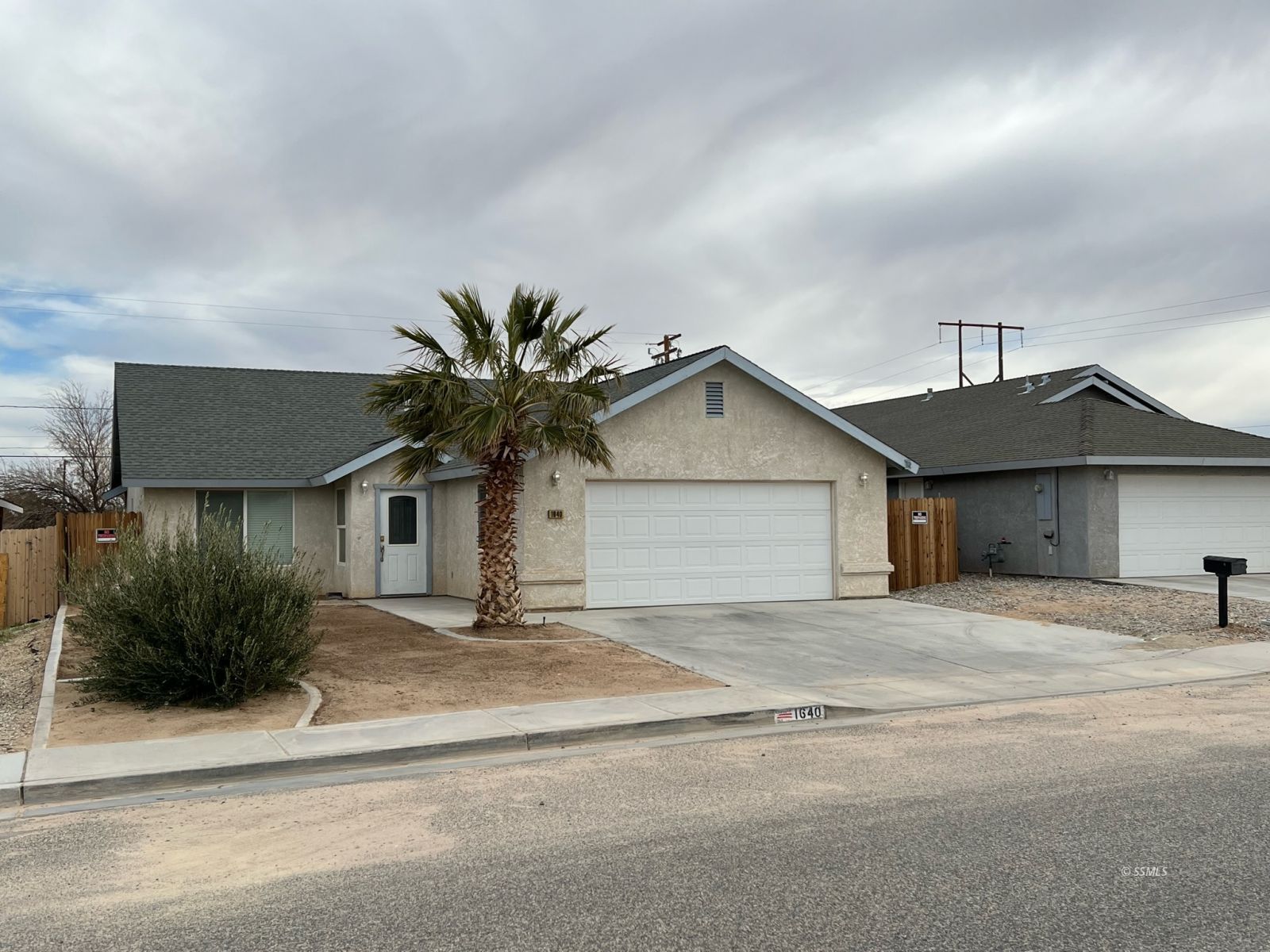 1640 South Mahan Street Ridgecrest, CA 93555 - Photo 2 of 27 a view of a house with a yard and garage