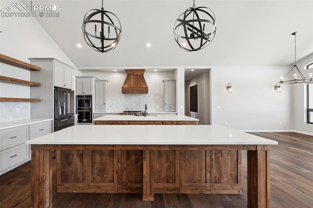 24365 Murphy Road Calhan, CO 80808 - Photo 16 of 48 Kitchen featuring a chandelier, a large island with sink, premium range hood, high end fridge, and open shelves