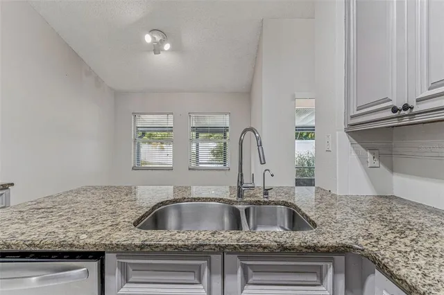 a bathroom with a granite countertop sink a toilet and shower