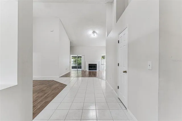 an empty room with a window and ceiling fan