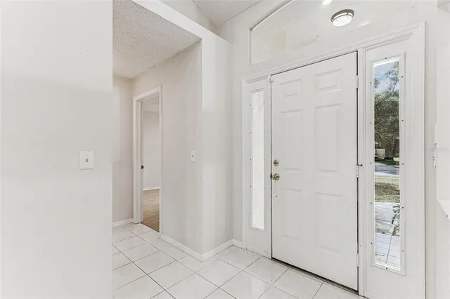 an empty room with wooden floor ceiling fan and window