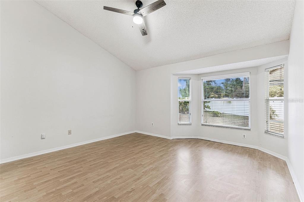 7206 Ridgeport Drive Tampa, FL 33647 - Photo 3 of 78 an empty room with wooden floor fan and windows