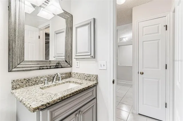 a kitchen with granite countertop white cabinets and stainless steel appliances