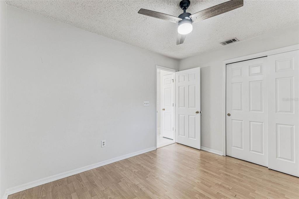 7206 Ridgeport Drive Tampa, FL 33647 - Photo 39 of 78 an empty room with wooden floor ceiling fan and window