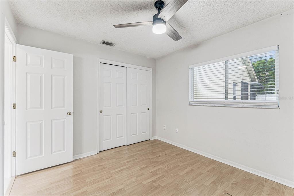 7206 Ridgeport Drive Tampa, FL 33647 - Photo 40 of 78 a view of empty room with wooden floor and fan