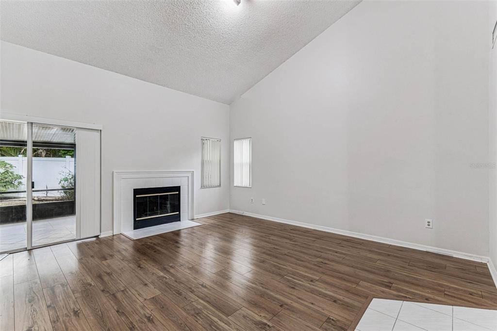 7206 Ridgeport Drive Tampa, FL 33647 - Photo 47 of 78 an empty room with wooden floor fireplace and windows