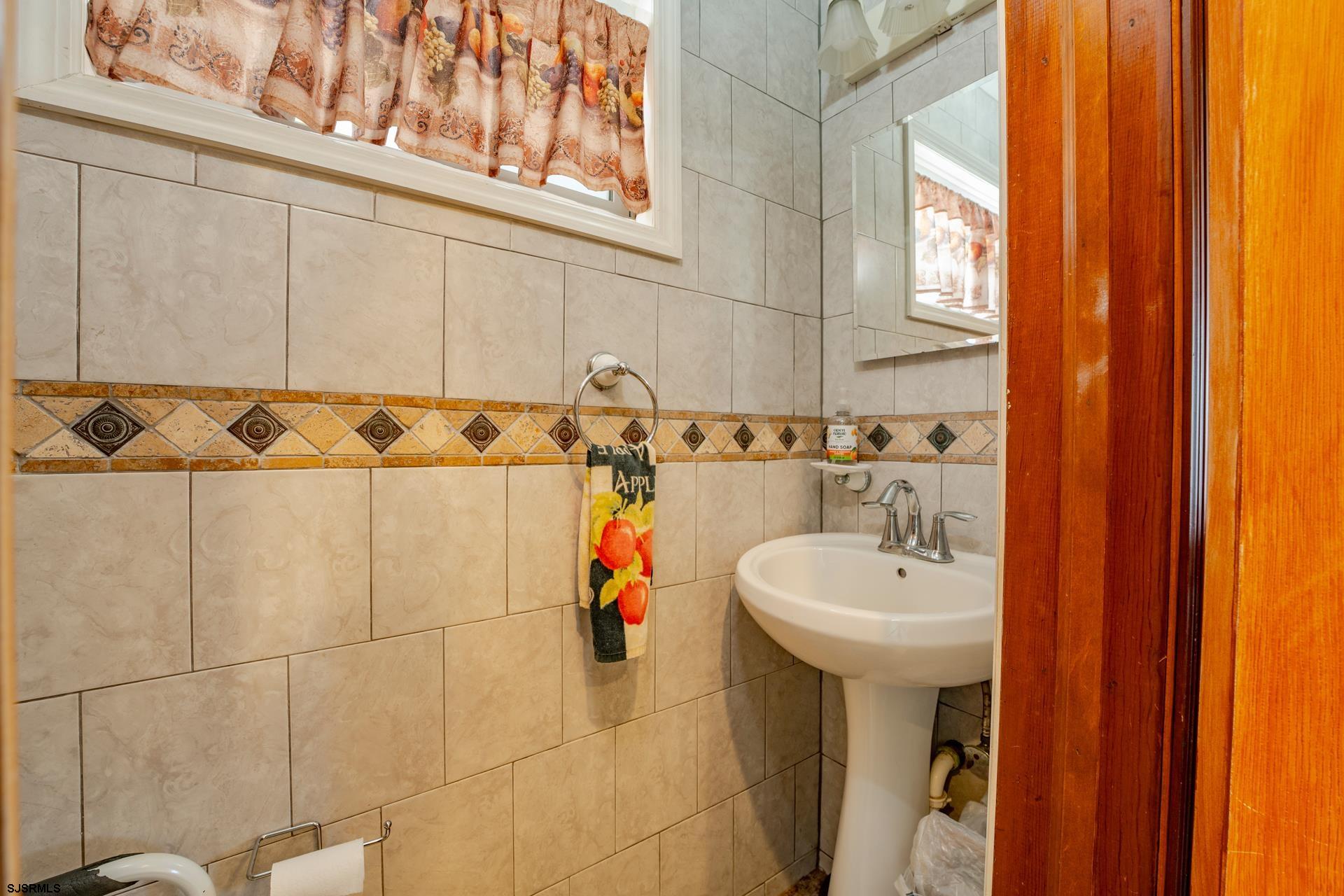 216 East Fern Road Wildwood Crest, NJ 08260 - Photo 66 of 93 a bathroom with a sink a mirror and a shower curtain