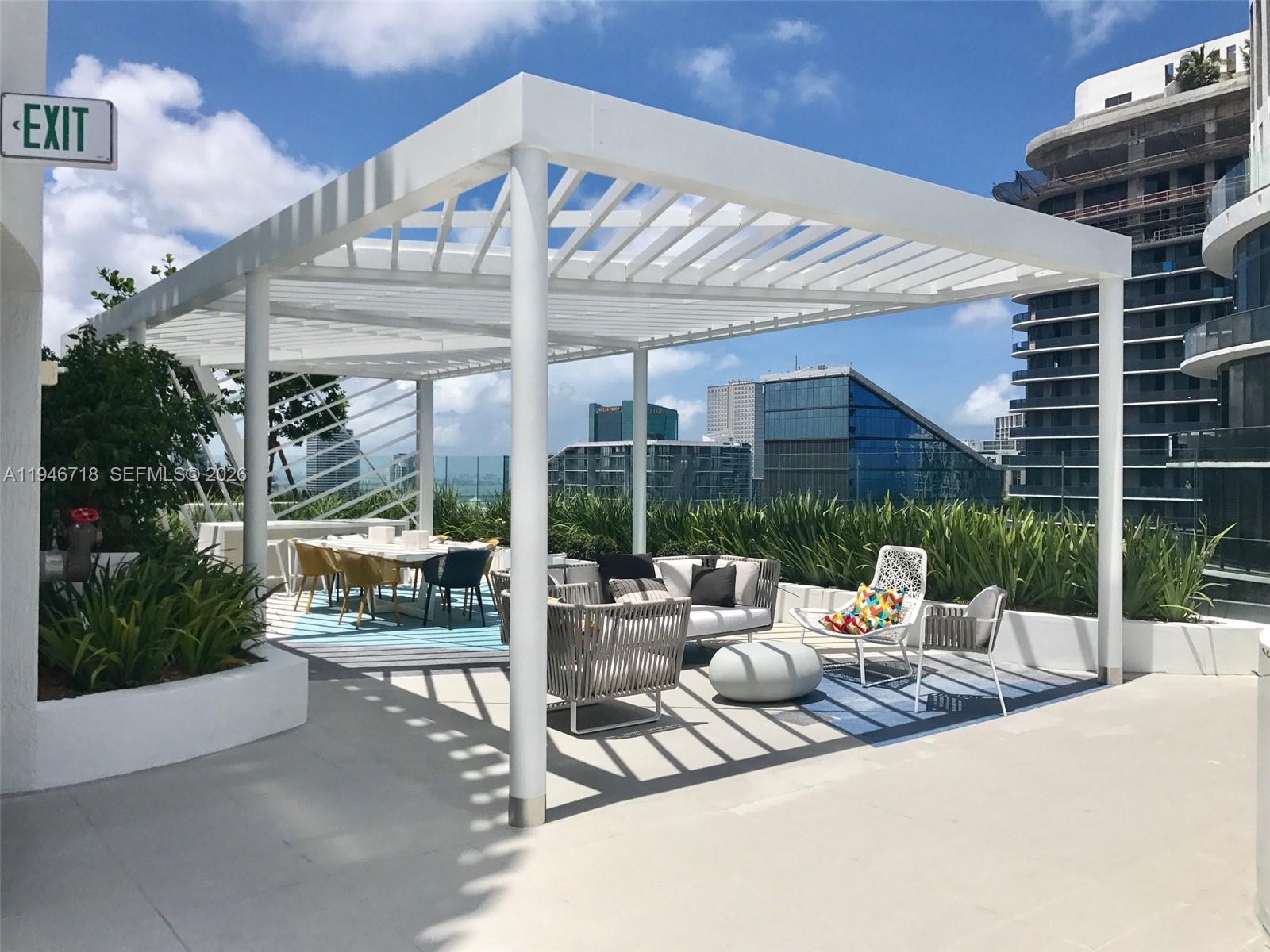 55 Southwest 9th Street, Unit 2807 Miami, FL 33130 - Photo 17 of 20 a view of a patio with a dining table and chairs under an umbrella