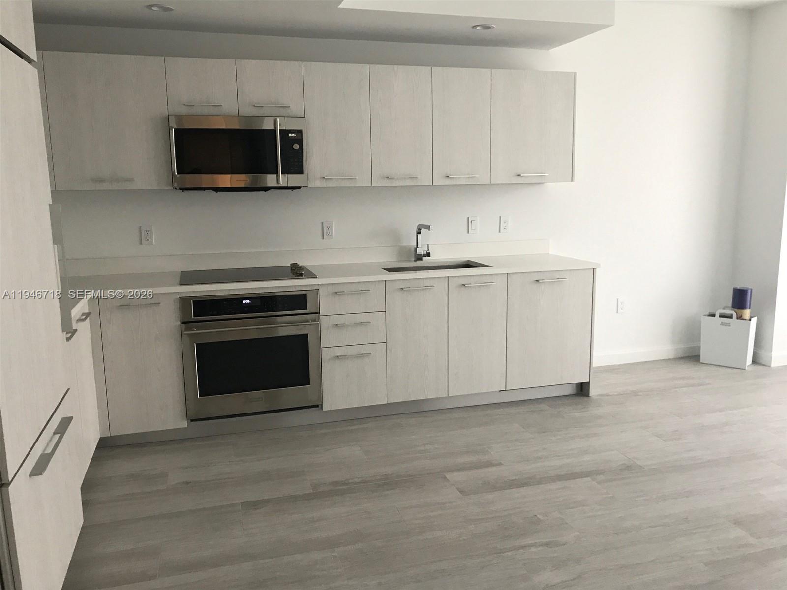 55 Southwest 9th Street, Unit 2807 Miami, FL 33130 - Photo 5 of 20 a kitchen with stainless steel appliances a stove a microwave and sink