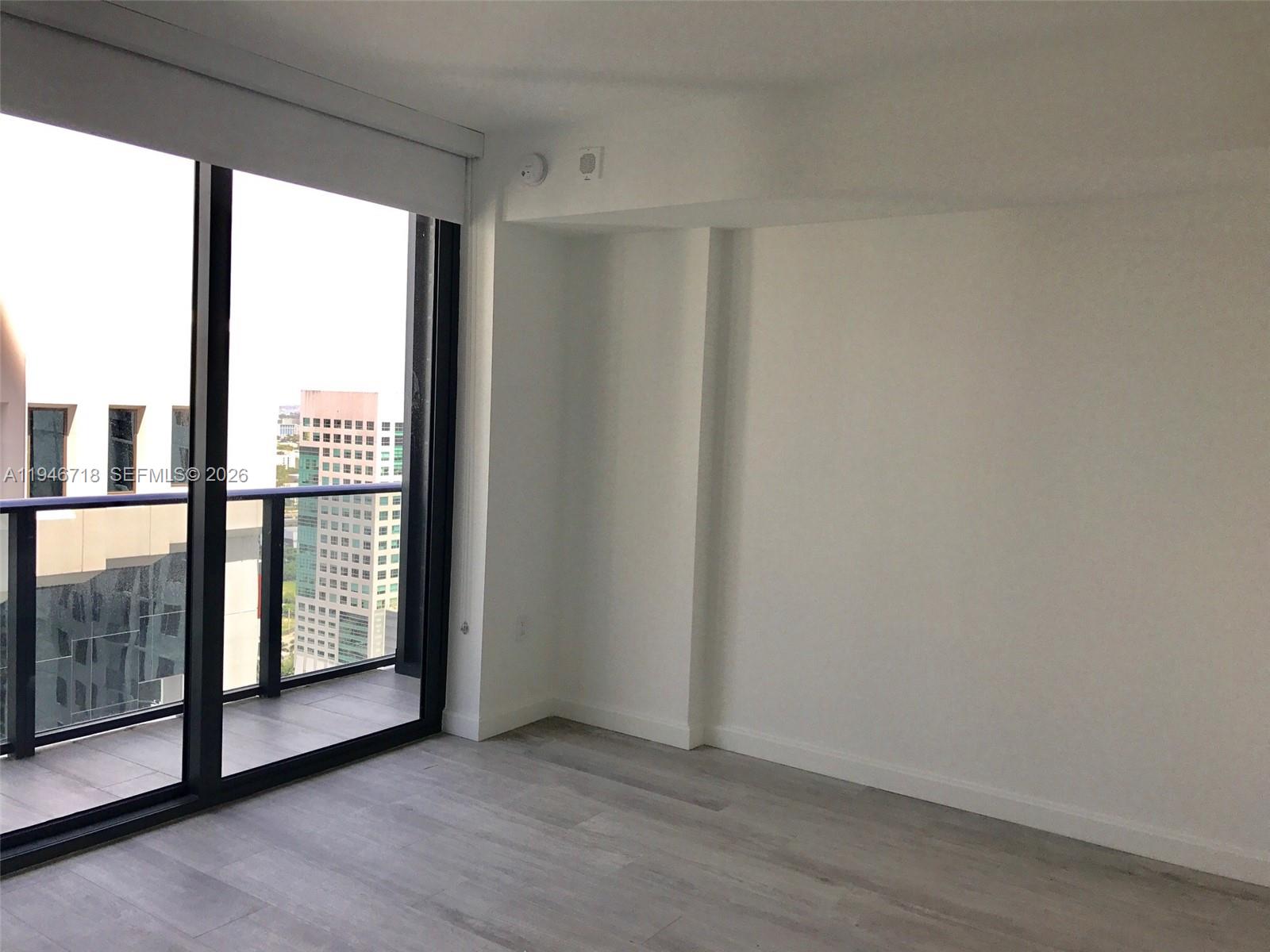 55 Southwest 9th Street, Unit 2807 Miami, FL 33130 - Photo 8 of 20 an empty room with wooden floor and windows