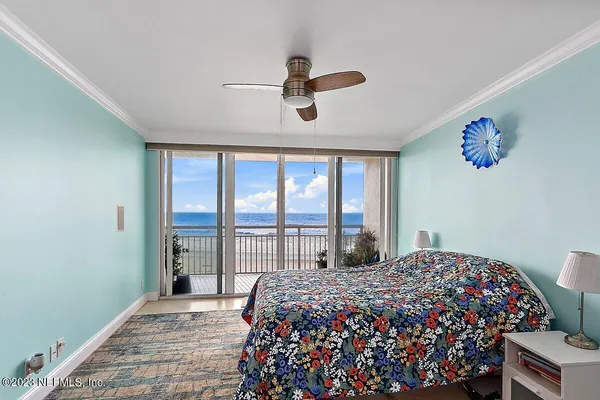 a bedroom with a large bed and a chandelier