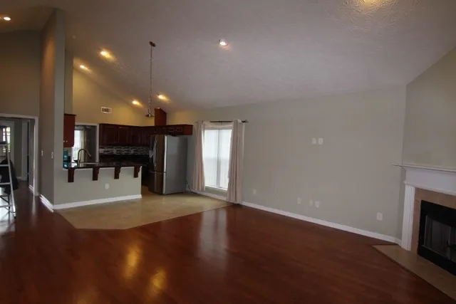 a view of a big room with wooden floor and a fireplace