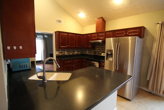 a kitchen with kitchen island a sink stove and refrigerator
